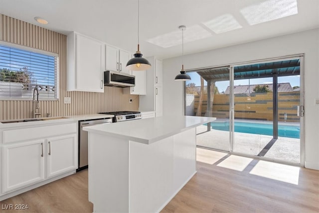 kitchen with pendant lighting, white cabinetry, sink, and appliances with stainless steel finishes