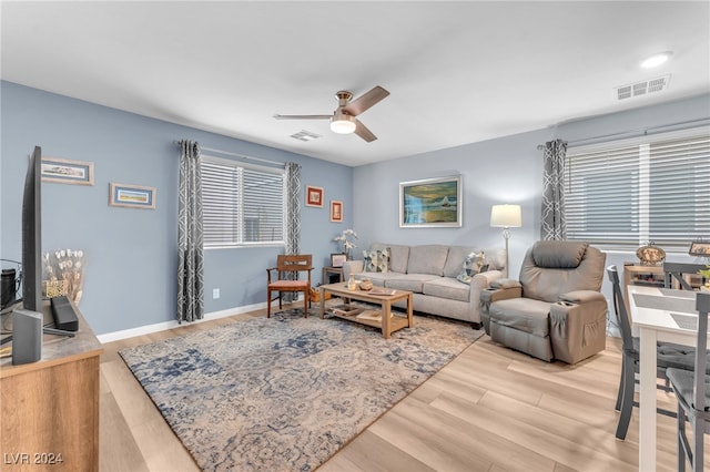 living room featuring light hardwood / wood-style flooring, a wealth of natural light, and ceiling fan