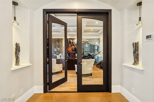 entryway with beam ceiling, french doors, wood-type flooring, and coffered ceiling