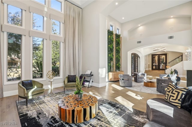 interior space with hardwood / wood-style floors, a wealth of natural light, and a high ceiling