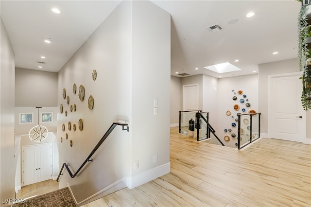 staircase with wood-type flooring and a skylight