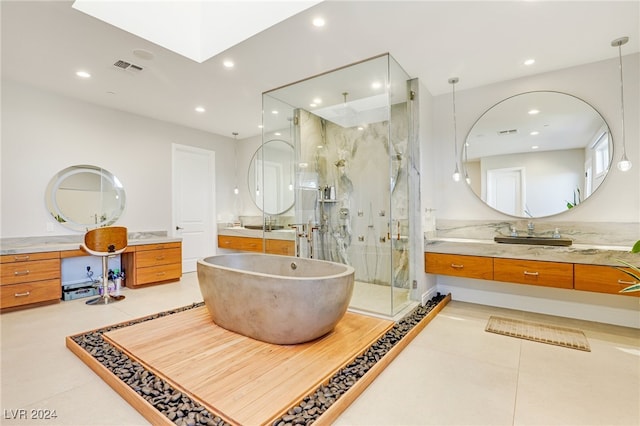 bathroom featuring plus walk in shower, vanity, and tile patterned flooring