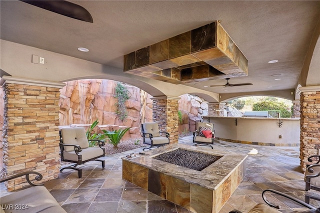 view of patio / terrace featuring ceiling fan and an outdoor fire pit