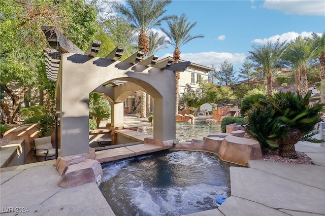 view of patio / terrace featuring a swimming pool with hot tub