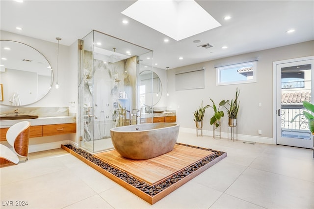 bathroom with tile patterned floors, a skylight, vanity, and walk in shower