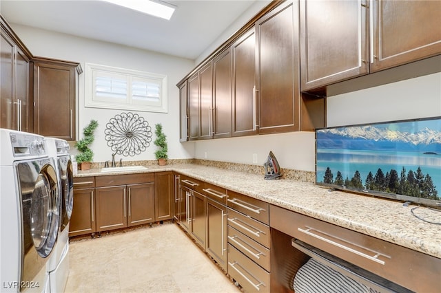 laundry area with cabinets, washer and clothes dryer, and sink