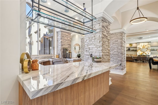 interior space with light stone counters, a high ceiling, and hardwood / wood-style flooring