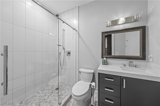 bathroom featuring vanity, toilet, and a shower with door