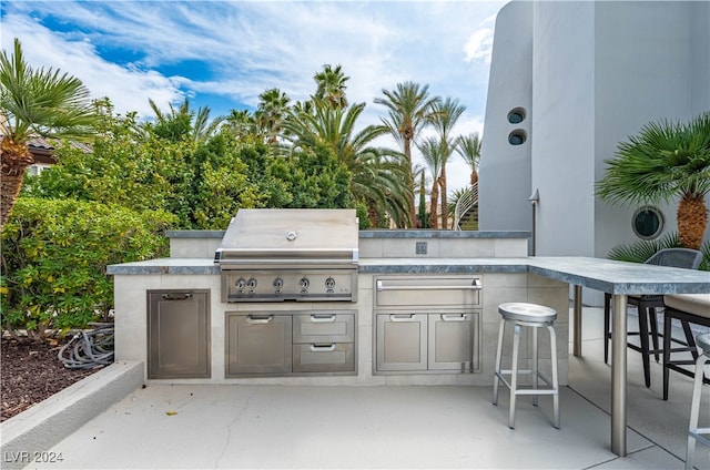 view of patio featuring an outdoor bar, area for grilling, and exterior kitchen