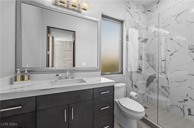 bathroom featuring a shower with door, vanity, and toilet