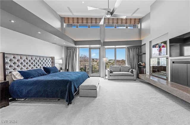 bedroom featuring ceiling fan, carpet floors, and a towering ceiling