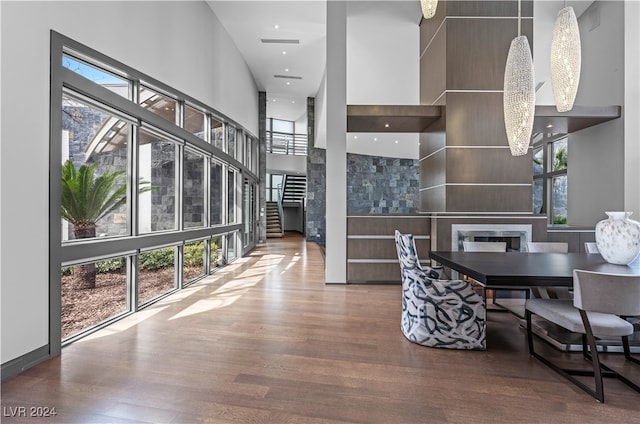 dining area with hardwood / wood-style flooring, plenty of natural light, a high ceiling, and a chandelier