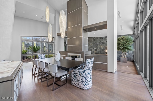 dining area featuring wood-type flooring and a high ceiling