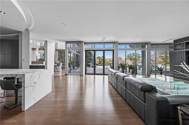 living room featuring dark hardwood / wood-style flooring, a wall of windows, and french doors