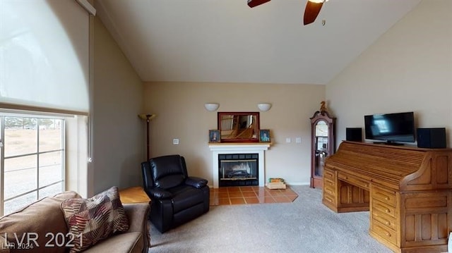 carpeted living room with ceiling fan and vaulted ceiling