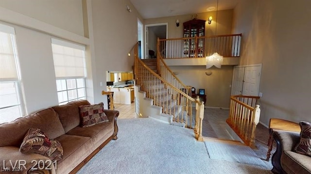 carpeted living room with a towering ceiling
