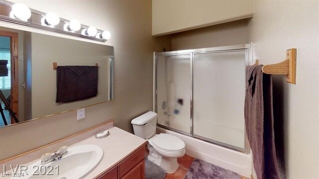 full bathroom featuring vanity, shower / bath combination with glass door, and toilet