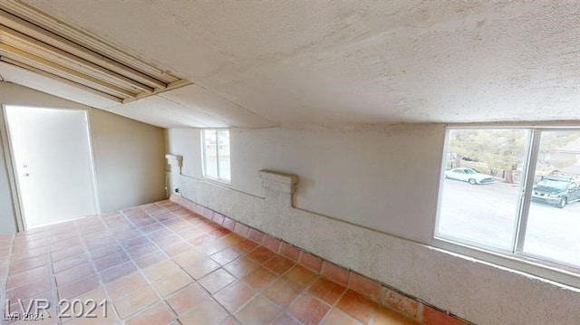 basement with light tile patterned flooring and a textured ceiling