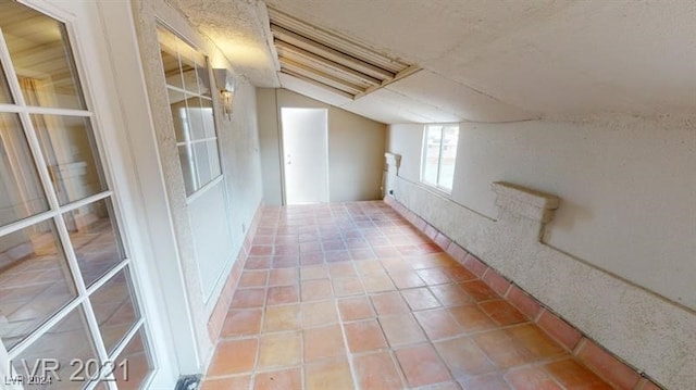 interior space featuring tile patterned flooring and vaulted ceiling