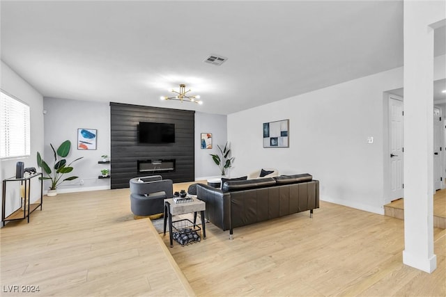 living room with a notable chandelier and light hardwood / wood-style floors