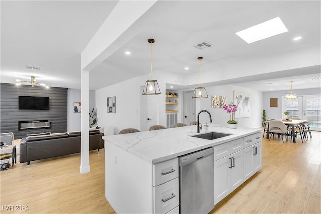 kitchen featuring dishwasher, sink, decorative light fixtures, a center island with sink, and white cabinets