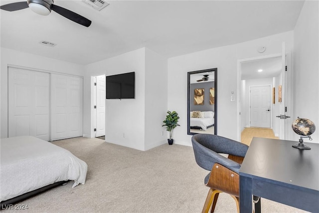 bedroom featuring ceiling fan, a closet, and light colored carpet