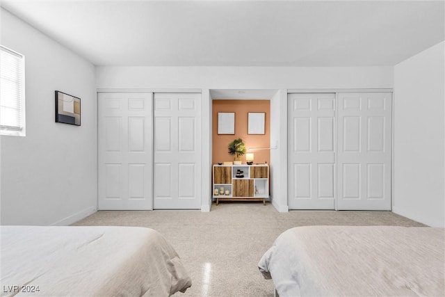 bedroom with two closets and light colored carpet