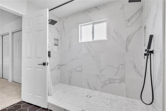 bathroom with tile patterned floors and tiled shower