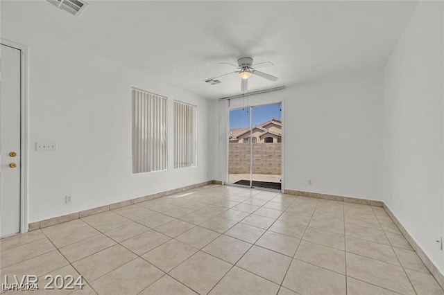 tiled spare room with ceiling fan