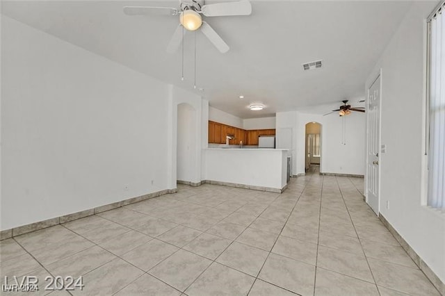 unfurnished living room featuring ceiling fan and light tile patterned floors