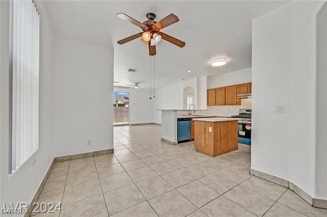 kitchen with ceiling fan, a center island, sink, light tile patterned floors, and appliances with stainless steel finishes