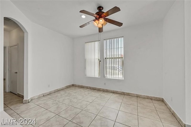 tiled spare room with ceiling fan