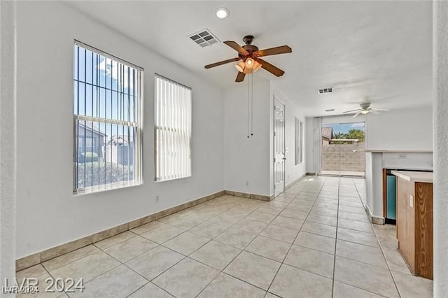 unfurnished living room featuring ceiling fan and light tile patterned floors