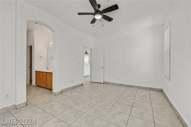 unfurnished room featuring ceiling fan, light tile patterned floors, and sink