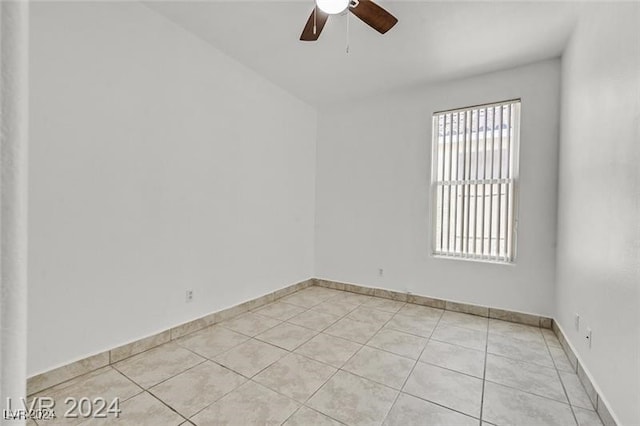 tiled spare room featuring ceiling fan