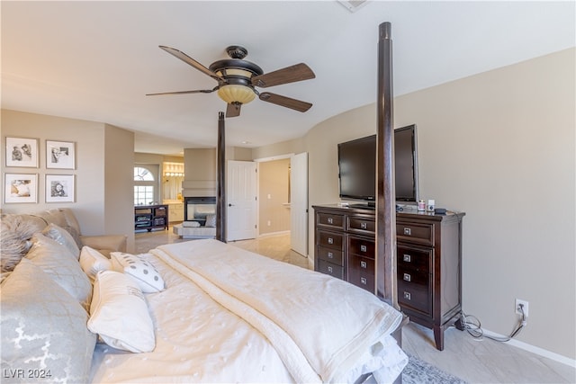 bedroom featuring ceiling fan and a fireplace