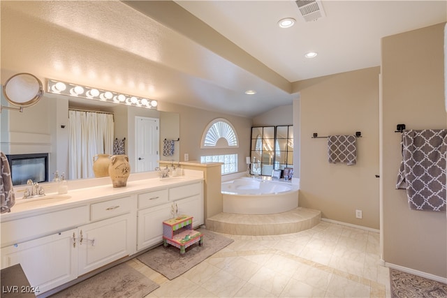 bathroom with lofted ceiling, vanity, tile patterned floors, and a tub