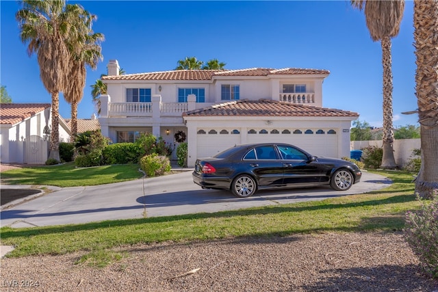 mediterranean / spanish-style house with a garage, a balcony, and a front yard