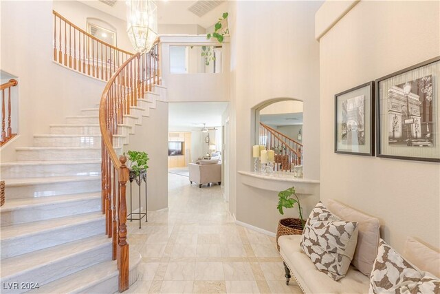 1819 Wild Indigo Ct, Las Vegas, NV 89123 - stairway with a chandelier, arched walkways, and a high ceiling