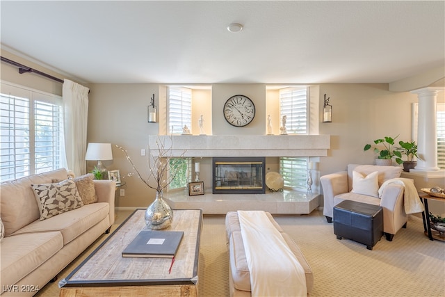 living room with ornate columns and a tiled fireplace