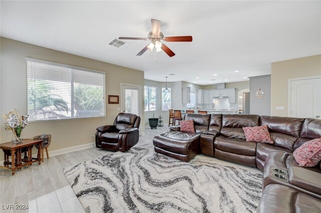 living room with ceiling fan and light hardwood / wood-style flooring