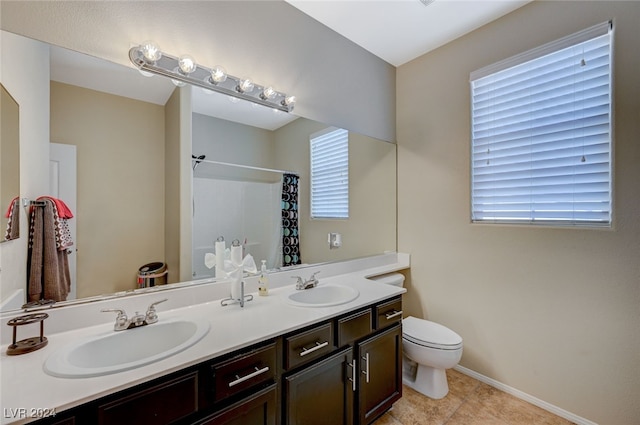 bathroom featuring a shower with shower curtain, tile patterned floors, vanity, and toilet