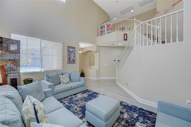 living room with hardwood / wood-style floors and high vaulted ceiling