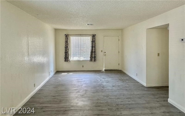 empty room with a textured ceiling and hardwood / wood-style flooring