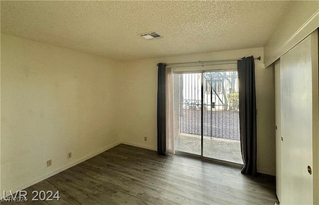 spare room with hardwood / wood-style floors and a textured ceiling