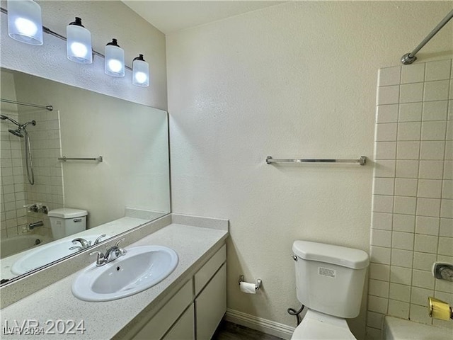 full bathroom featuring vanity, tiled shower / bath combo, and toilet