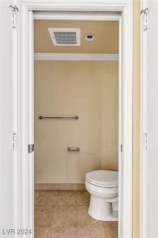 bathroom featuring tile patterned floors, toilet, and ornamental molding