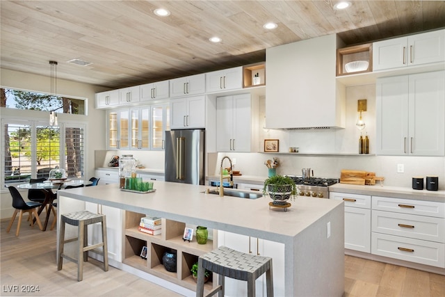 kitchen featuring white cabinetry, sink, an island with sink, pendant lighting, and appliances with stainless steel finishes