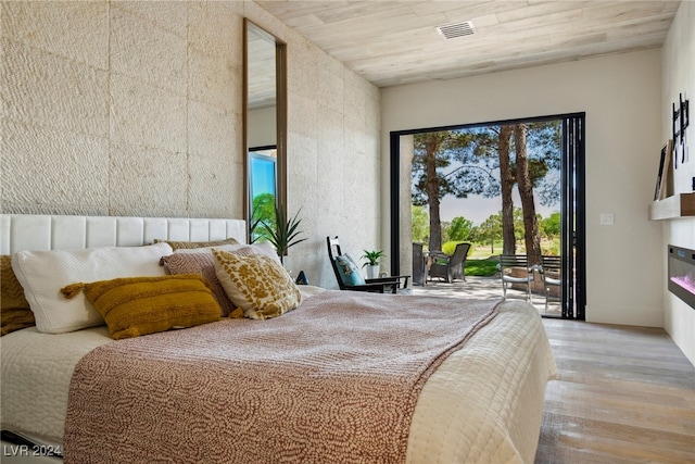 bedroom with access to outside, wooden ceiling, and light hardwood / wood-style floors