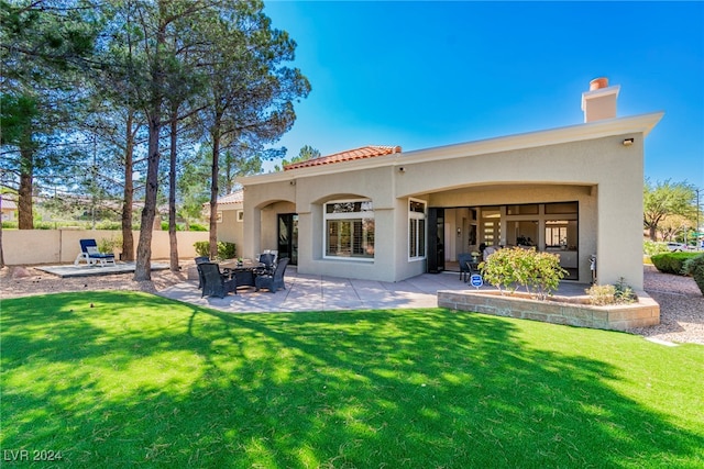 back of property with a lawn and a patio